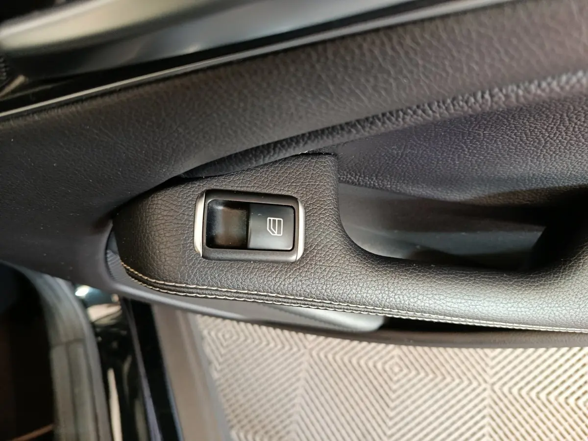Gros plan sur la commande de lève-vitre côté gauche en cuir noir avec surpiqûres dans une Mercedes GLA 220 d Business Exec 2018.
