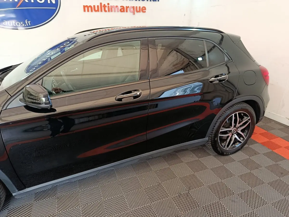 Vue latérale côté gauche d'une Mercedes GLA 220 d Business Exec noire, soulignant ses jantes alliage et rétroviseurs chromés.