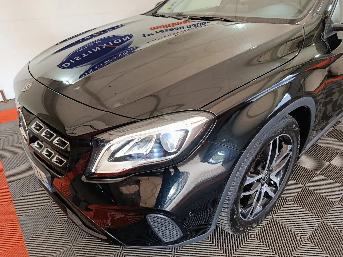 Vue 3/4 avant gauche d'une Mercedes GLA 220 d Business noire, mettant en valeur son phare LED et sa calandre distinctive.