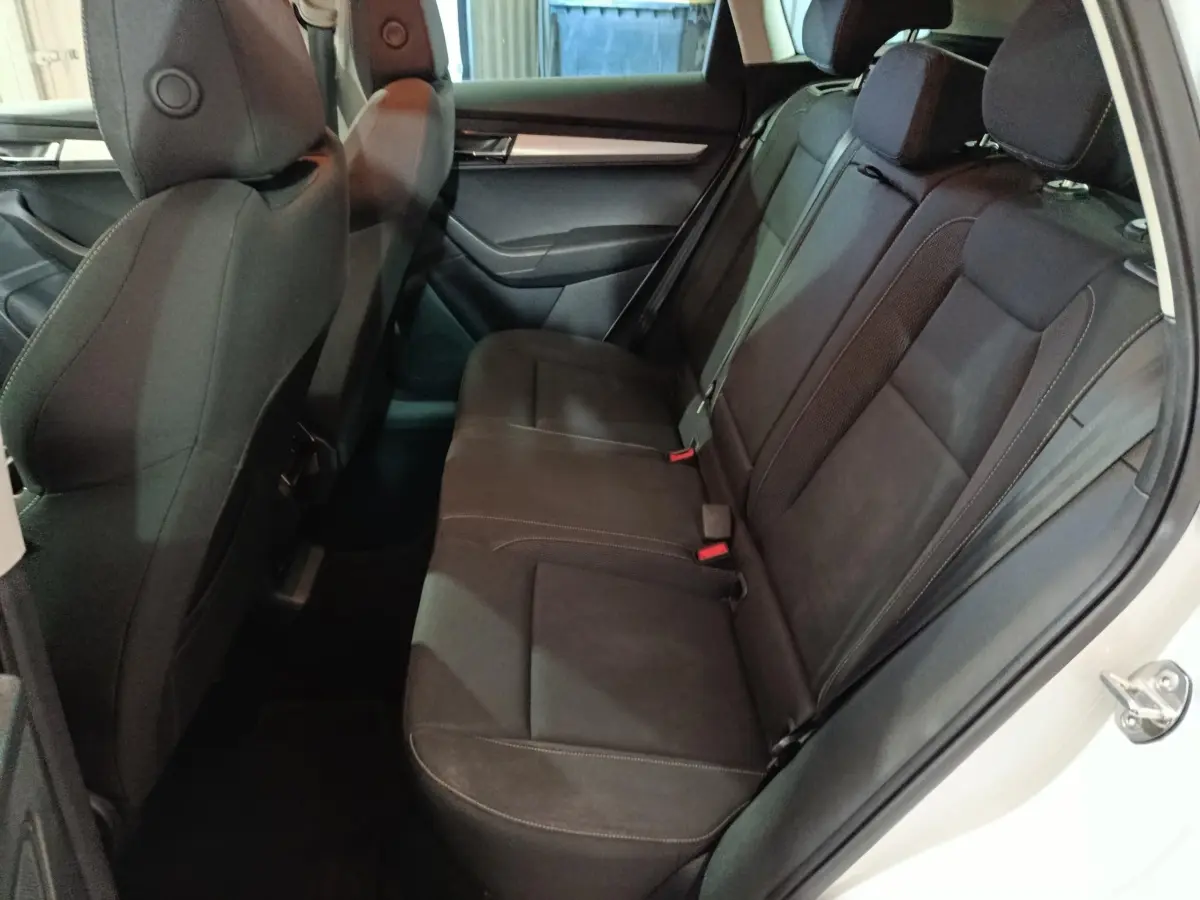 Vue côté droit de la banquette arrière noire du Skoda Karoq 2024 avec appuie-têtes et ceintures visibles.