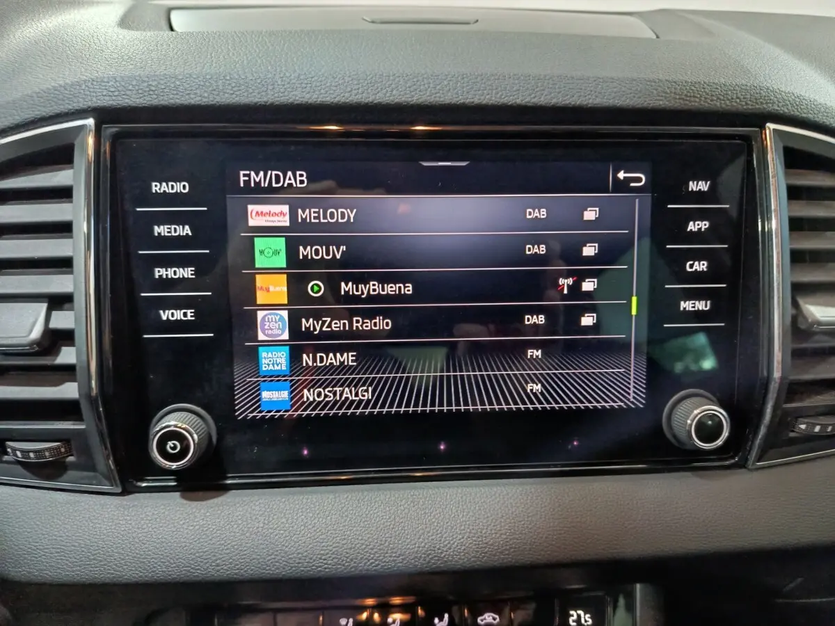 Écran tactile central affichant les stations radio dans l'habitacle gris du Skoda Karoq 2024 diesel.