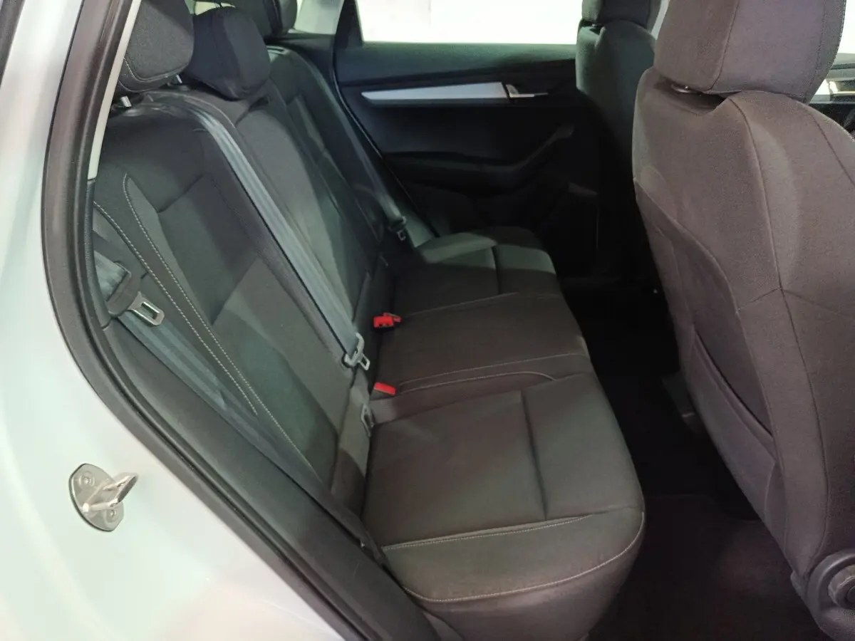 Vue intérieure côté gauche des sièges arrière noirs du Skoda Karoq 2024, montrant la banquette et les appuie-têtes.