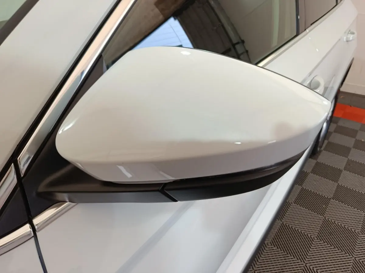 Rétroviseur côté gauche blanc du Skoda Karoq 2024, avec caméra intégrée et carrosserie blanche vue de près.