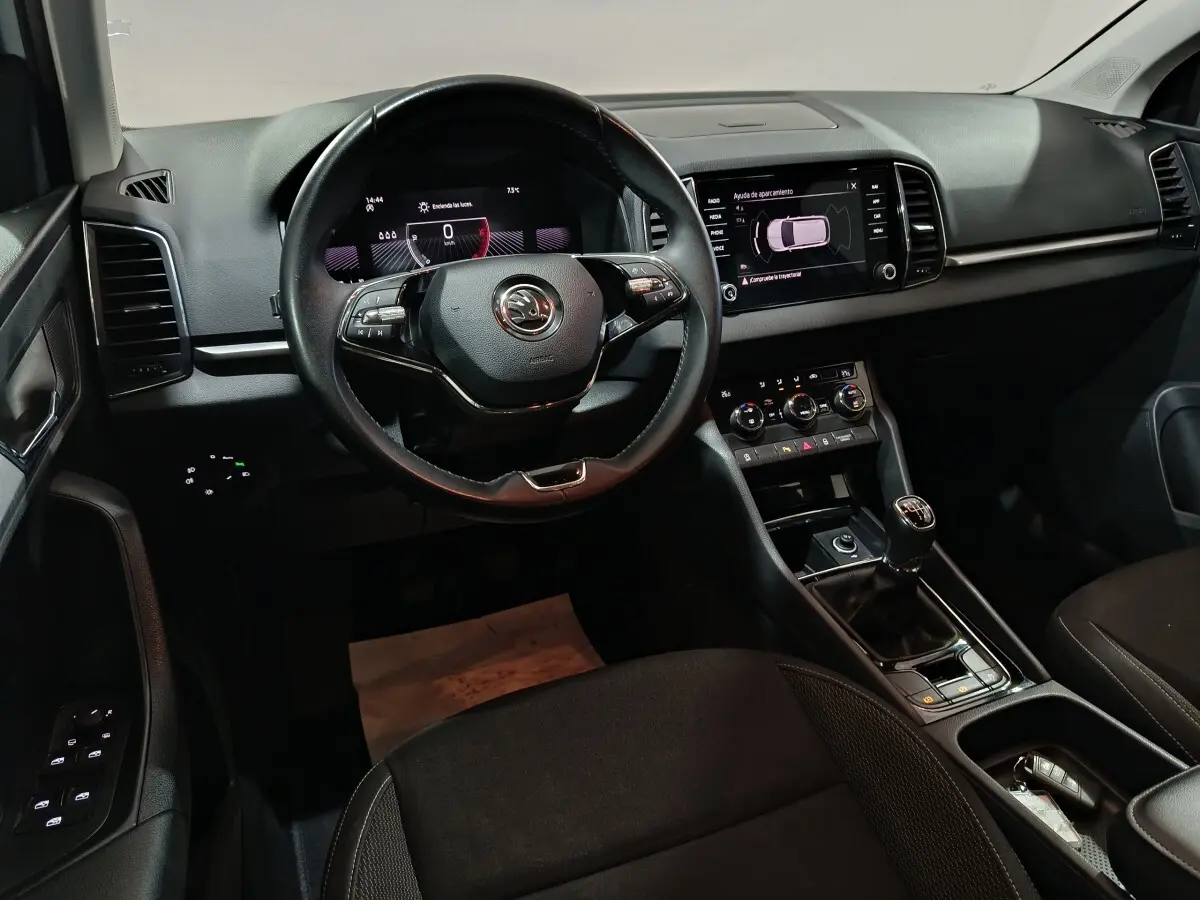 Intérieur noir du Skoda Karoq 2024, vue de face sur le volant cuir, tableau de bord digital et écran tactile central.