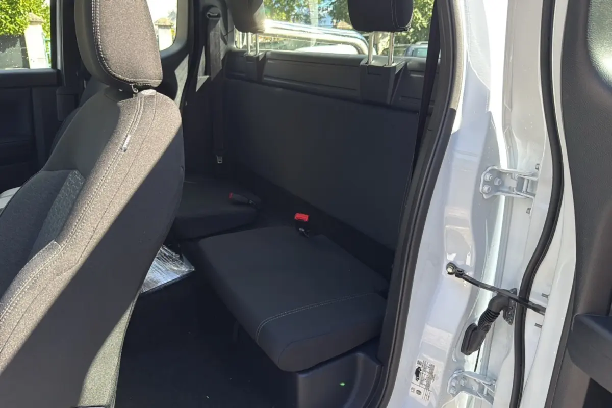 Vue intérieure côté arrière droit du Ford Ranger blanc glacier, montrant la banquette arrière et l'ouverture de la porte supercab.