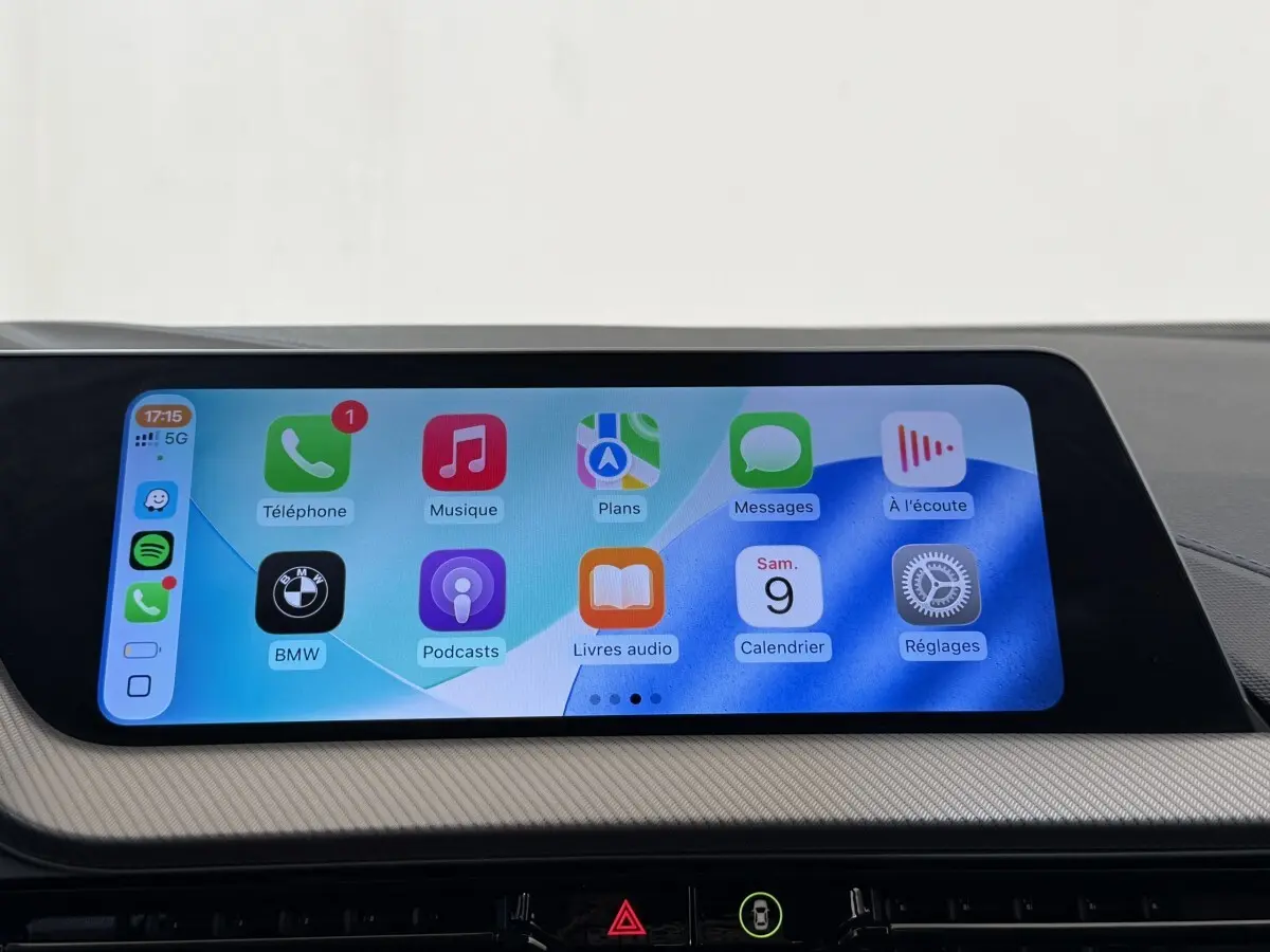 Écran tactile central de la BMW Série 1 120i Edition M Sport Pro affichant interface Apple CarPlay colorée.