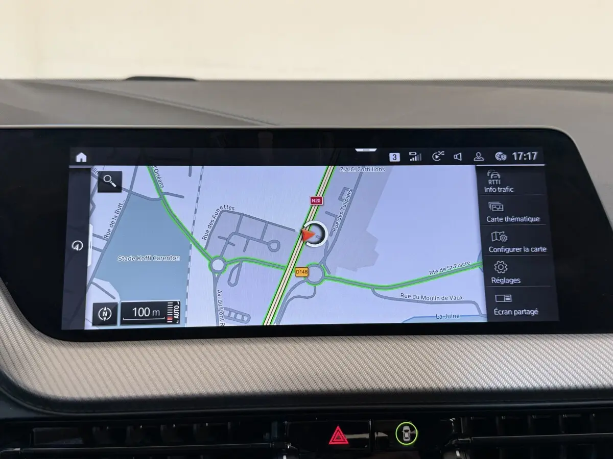 Écran tactile central de navigation 3D affichant une carte routière dans l’habitacle d’une BMW Série 1 noire.