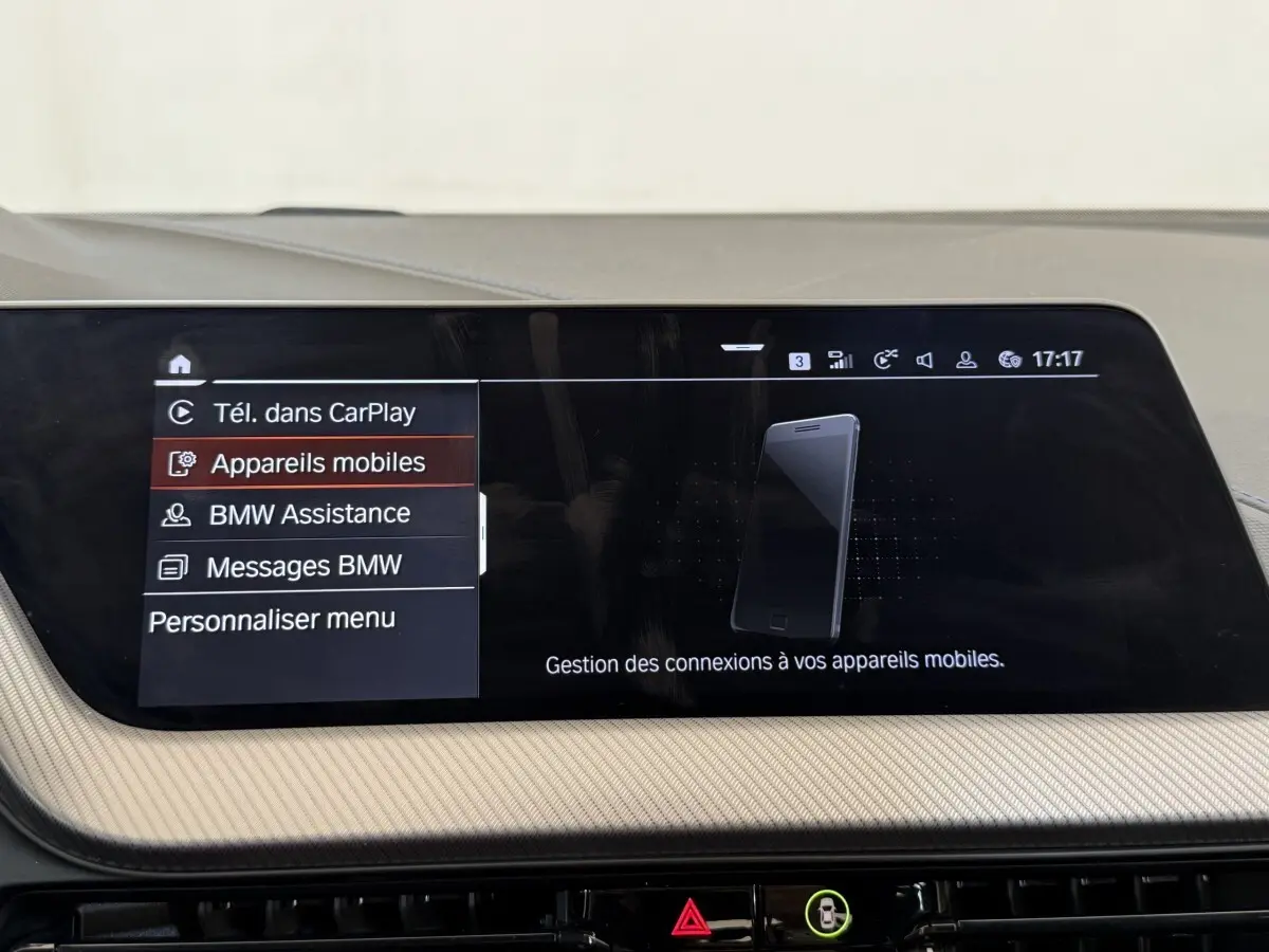 Intérieur de BMW Série 1 120i Edition M Sport Pro 2023, écran tactile central affichant menu connectivité mobile.