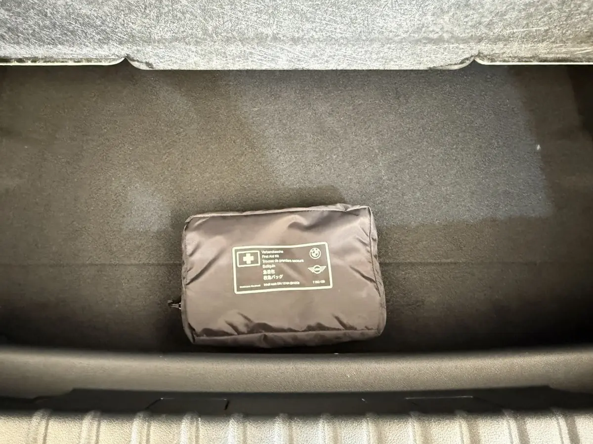 Vue plongeante sur le coffre noir d’une BMW Série 1 120i Edition M Sport Pro avec trousse de secours noire.