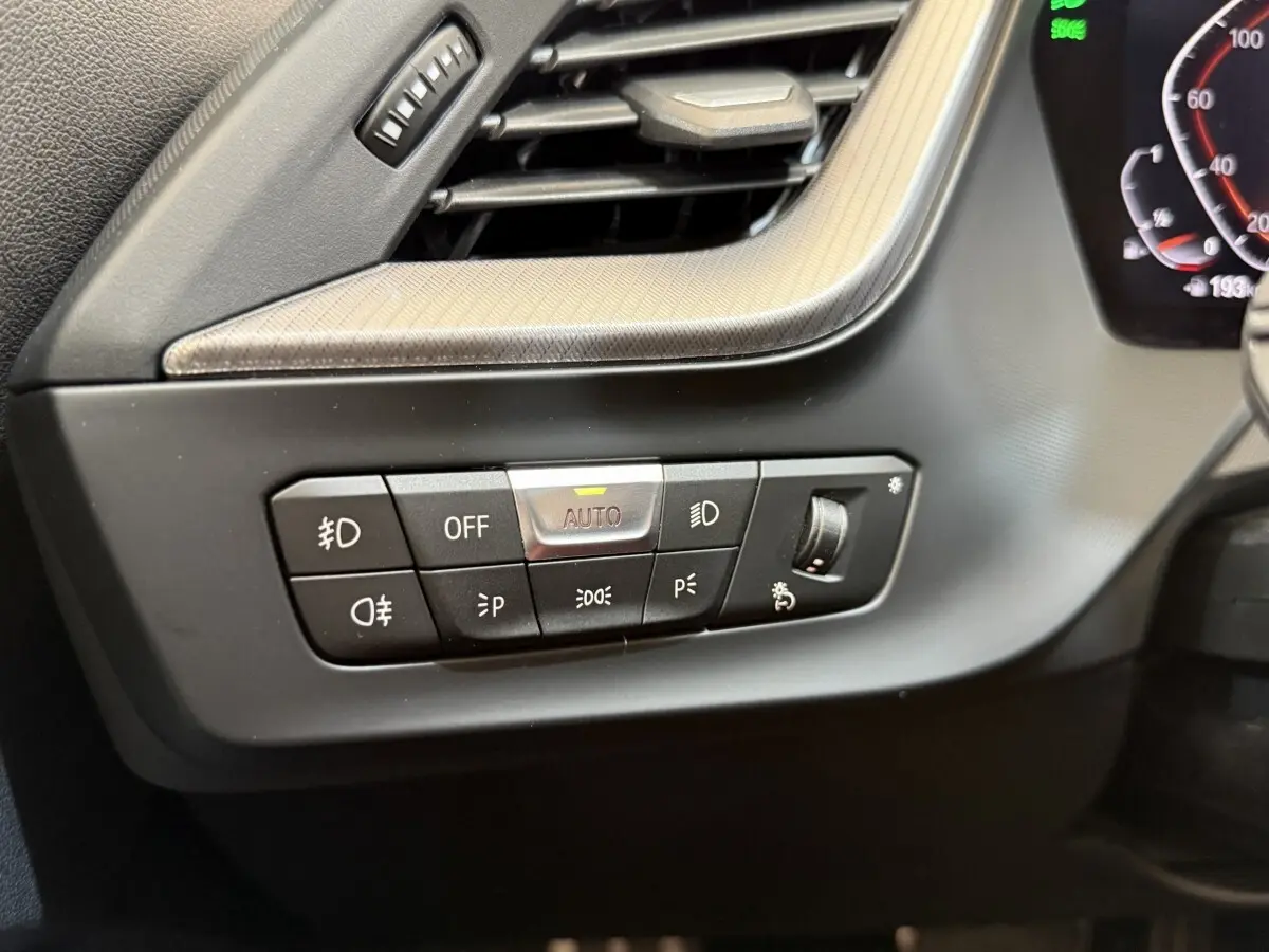 Gros plan sur les commandes d’éclairage intérieures noires de la BMW Série 1 120i Edition M Sport Pro 2023.