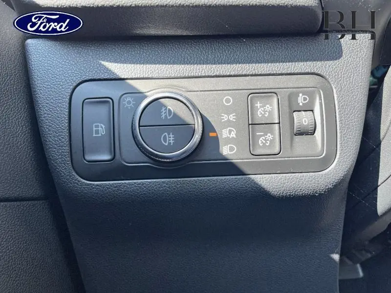 Gros plan sur les commandes d'éclairage et réglage du tableau de bord du Ford Kuga 2022 en intérieur noir texturé