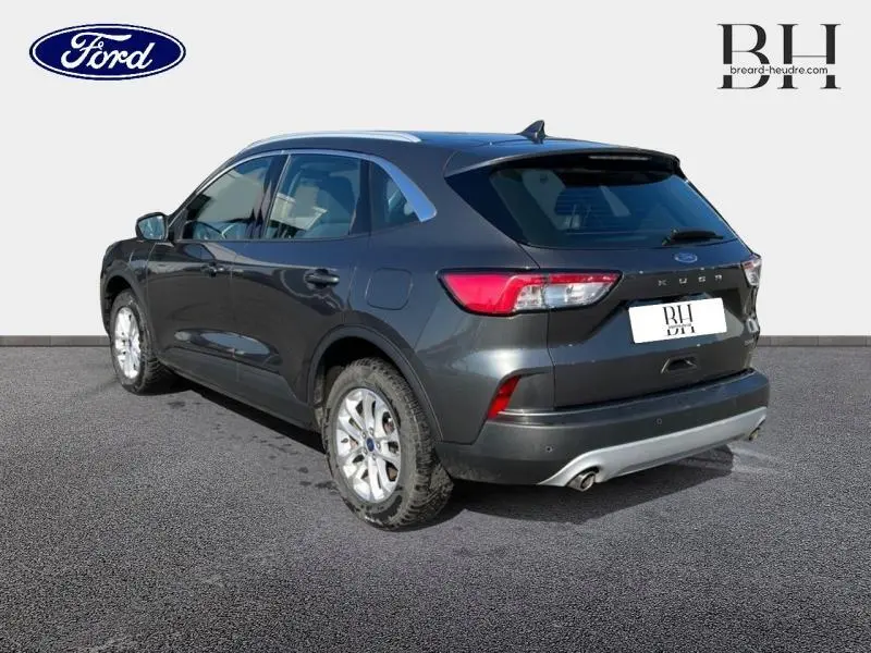Vue 3/4 arrière droite du Ford Kuga gris métallisé avec feux arrière LED et double sortie d'échappement visible.