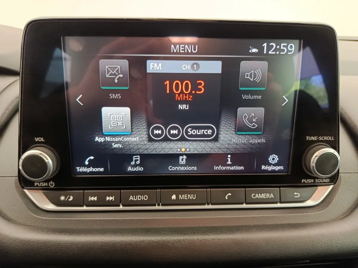 Écran tactile central du Nissan Qashqai e-Power 2024 affichant la radio FM 100.3 MHz avec commandes physiques en dessous.