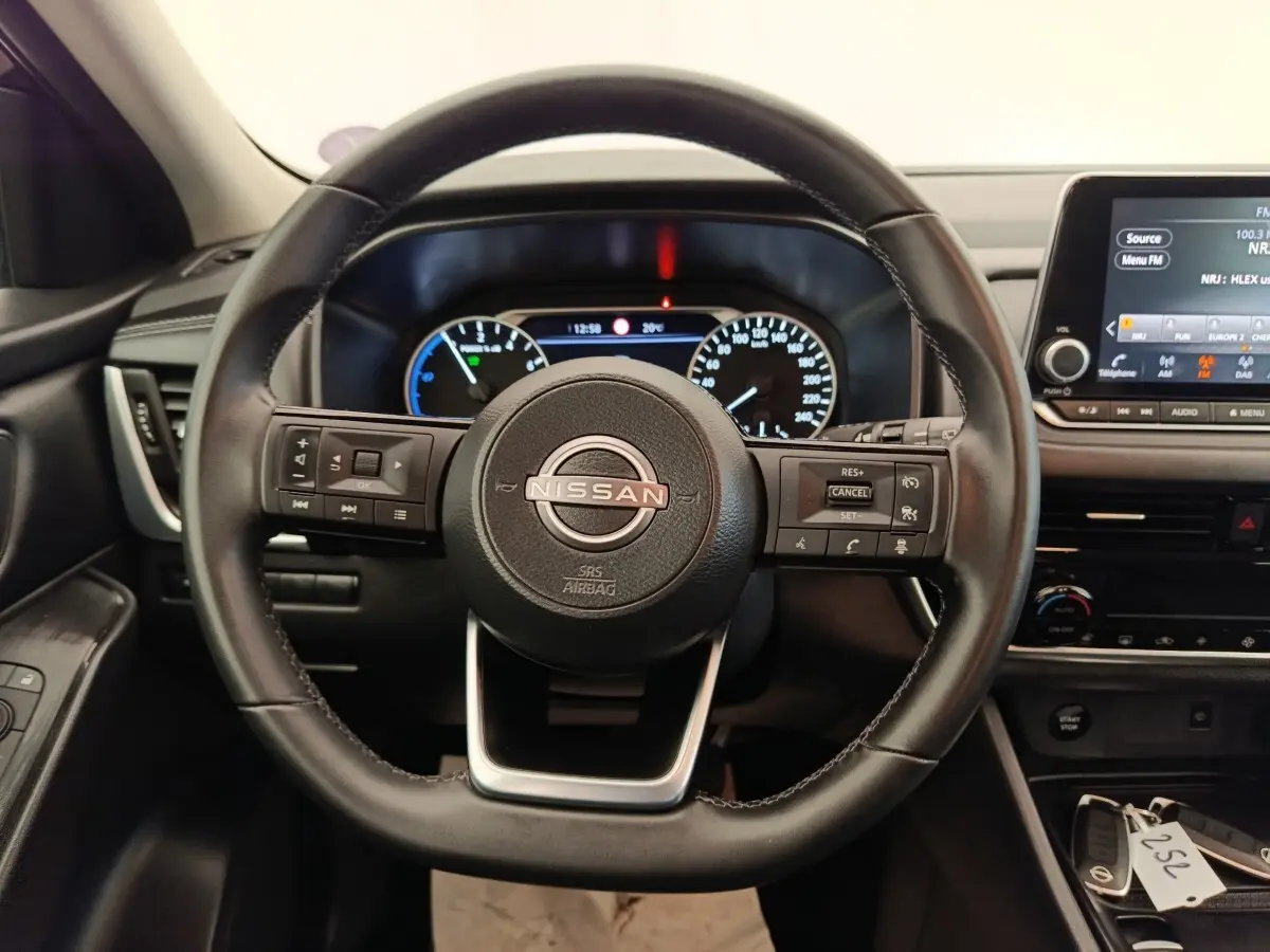 Vue centrée sur le volant cuir noir du Nissan Qashqai e-Power 2024 avec tableau de bord et écran tactile visibles.