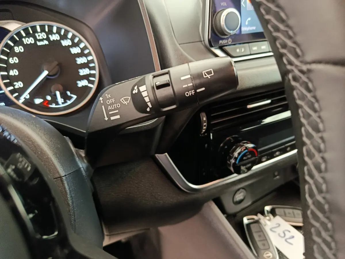 Vue rapprochée du commodo d’essuie-glace et du tableau de bord du Nissan Qashqai e-Power noir, avec volant partiel visible.