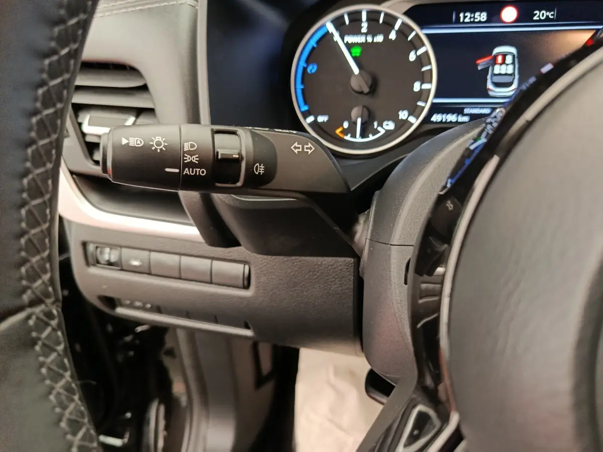 Gros plan sur la manette de commande des phares et clignotants côté gauche du tableau de bord du Nissan Qashqai noir 2024.