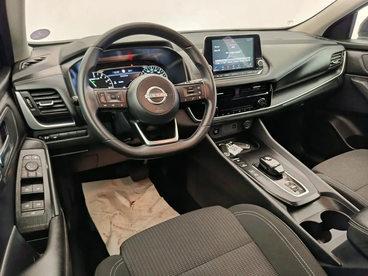 Vue intérieure du poste de conduite du Nissan Qashqai e-Power 190 Business Edition BVA 2024, avec volant cuir multifonctions et écran tactile central.