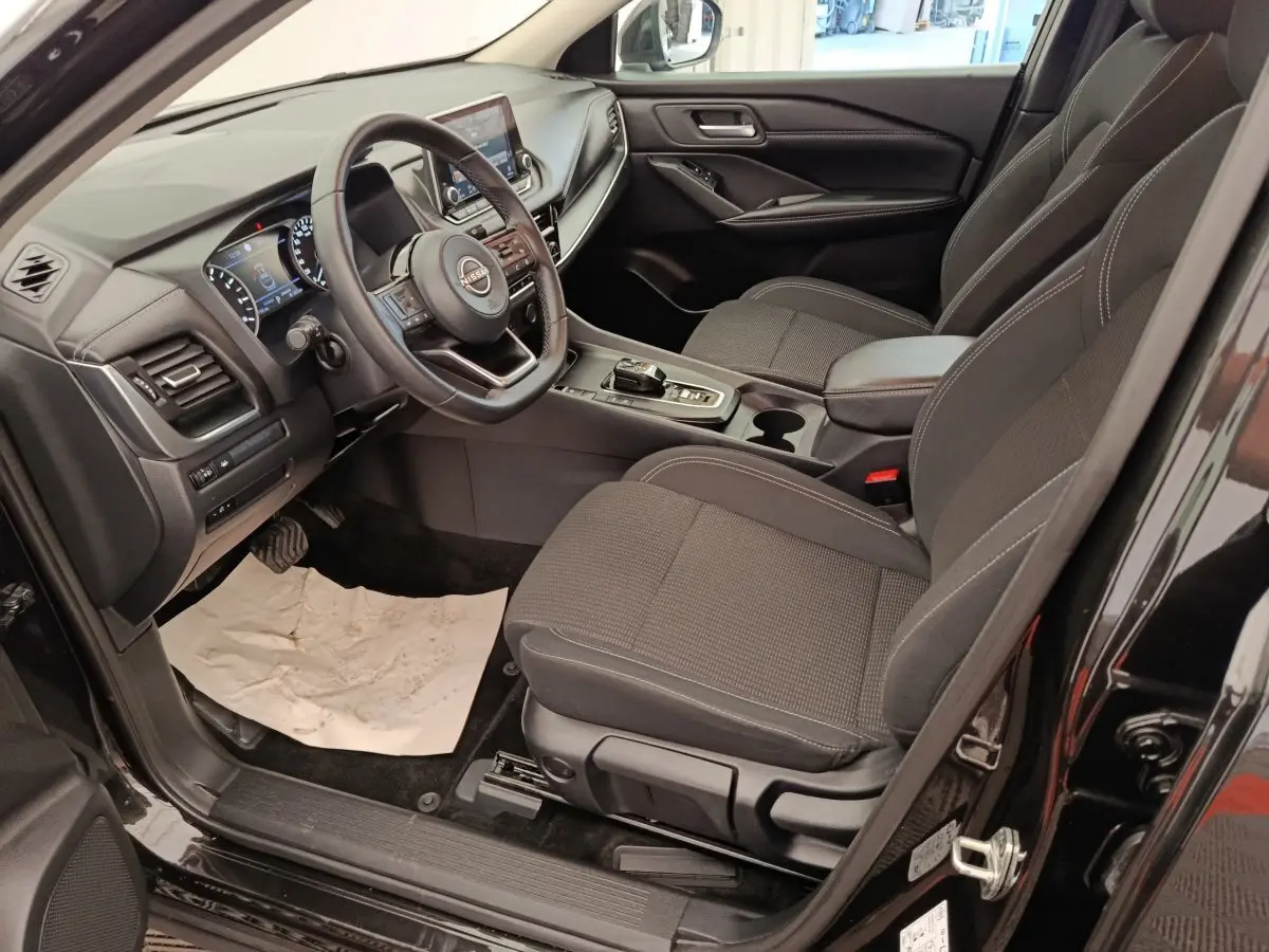 Vue intérieure côté conducteur du Nissan Qashqai e-Power 190 Business Edition BVA 2024 noir, avec tableau de bord et volant multifonctions.