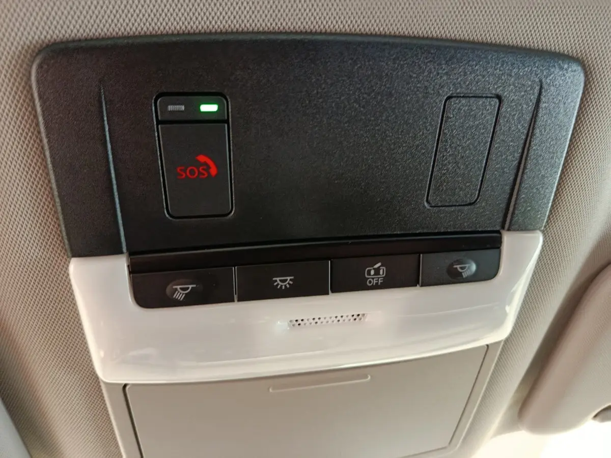 Vue rapprochée du plafonnier intérieur noir et beige du Nissan Qashqai 2024 avec bouton SOS rouge et commandes d’éclairage.