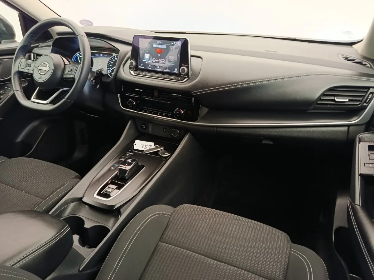 Vue intérieure du tableau de bord et console centrale du Nissan Qashqai e-Power 190 Business Edition BVA noir, avec écran tactile et volant multifonctions.