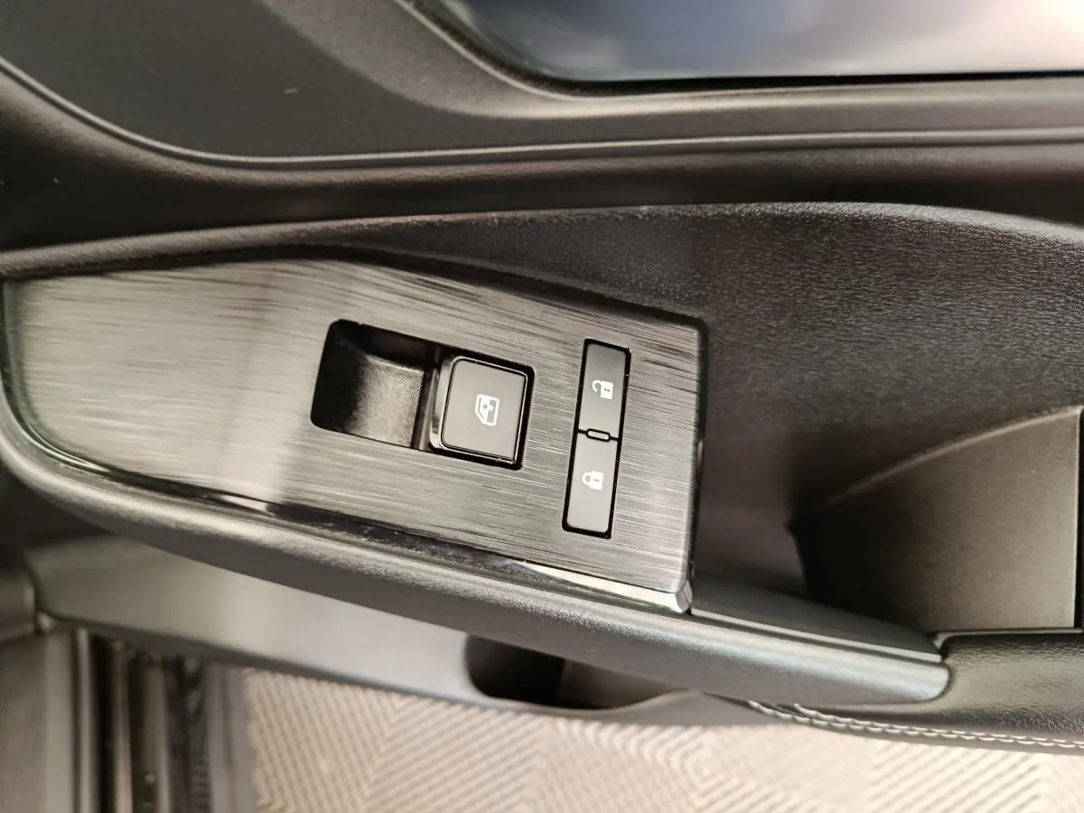 Détail des commandes de lève-vitre et verrouillage sur la porte côté conducteur du Nissan Qashqai e-Power noir 2024.