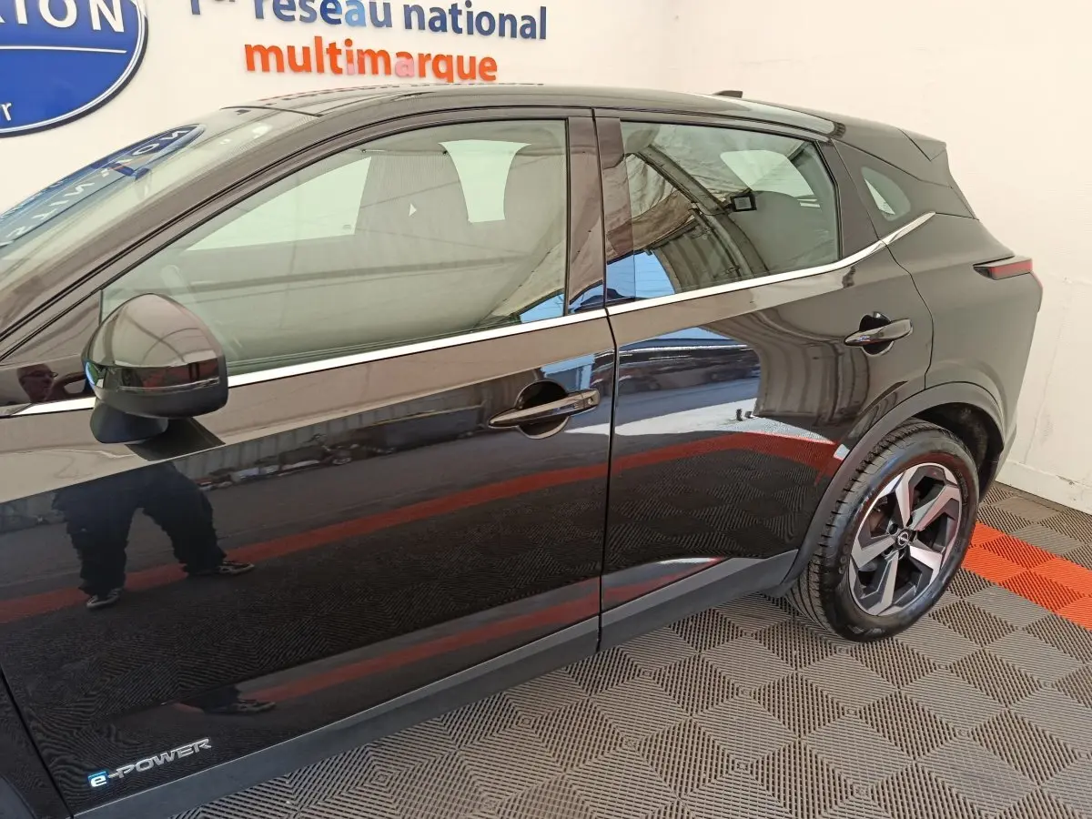 Profil côté gauche du Nissan Qashqai e-Power noir 2024 avec jantes alliage et logo e-Power visible sur la porte avant.