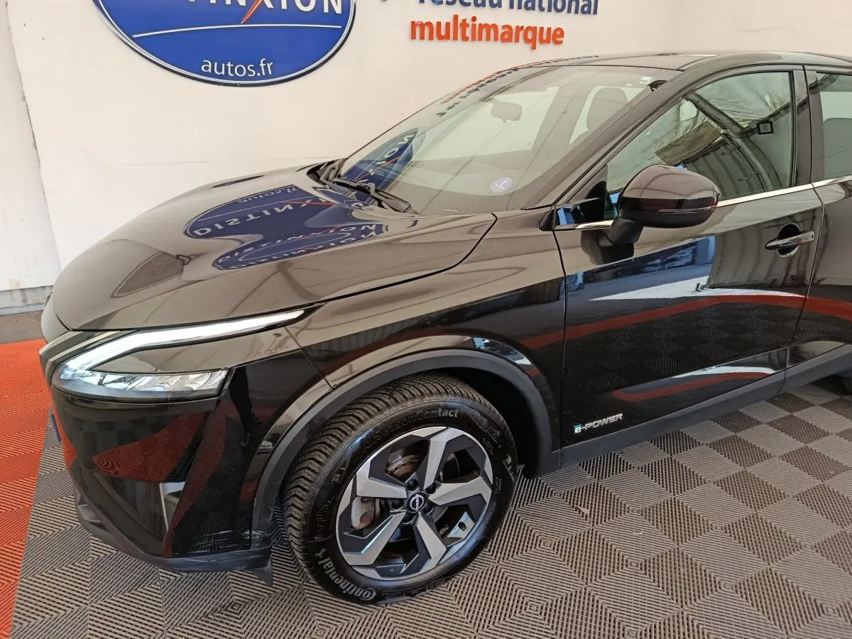Vue 3/4 avant droit du Nissan Qashqai e-Power noir, mettant en valeur ses phares LED et jantes alliage distinctives.