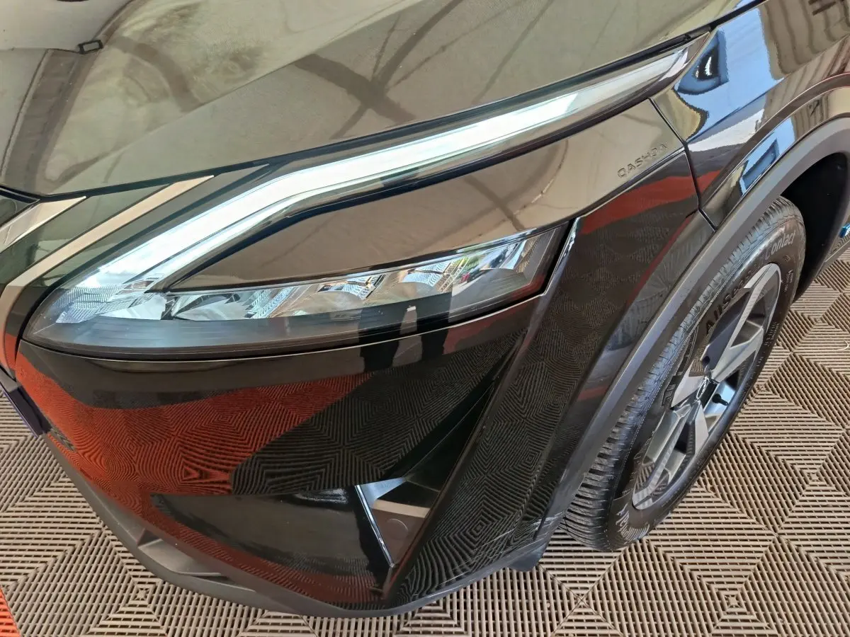 Gros plan sur l'avant droit noir du Nissan Qashqai e-Power 190 avec phare LED et jante alliage visible.