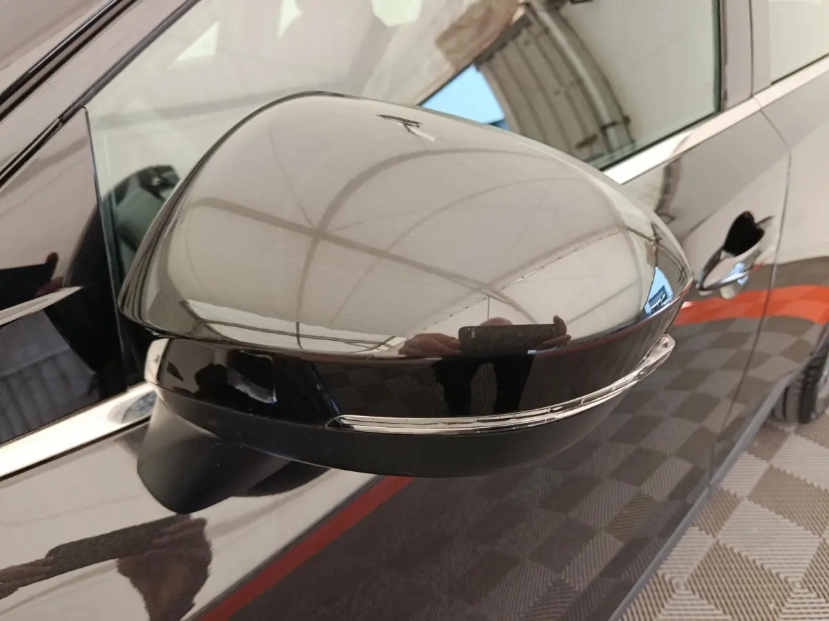 Gros plan sur le rétroviseur côté conducteur noir brillant du Nissan Qashqai e-Power 190 Business Edition 2024.