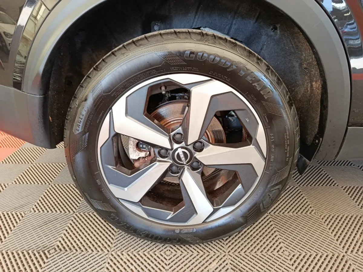 Gros plan sur la roue avant droite du Nissan Qashqai e-Power 190 Business Edition noire avec jante alliage bicolore.