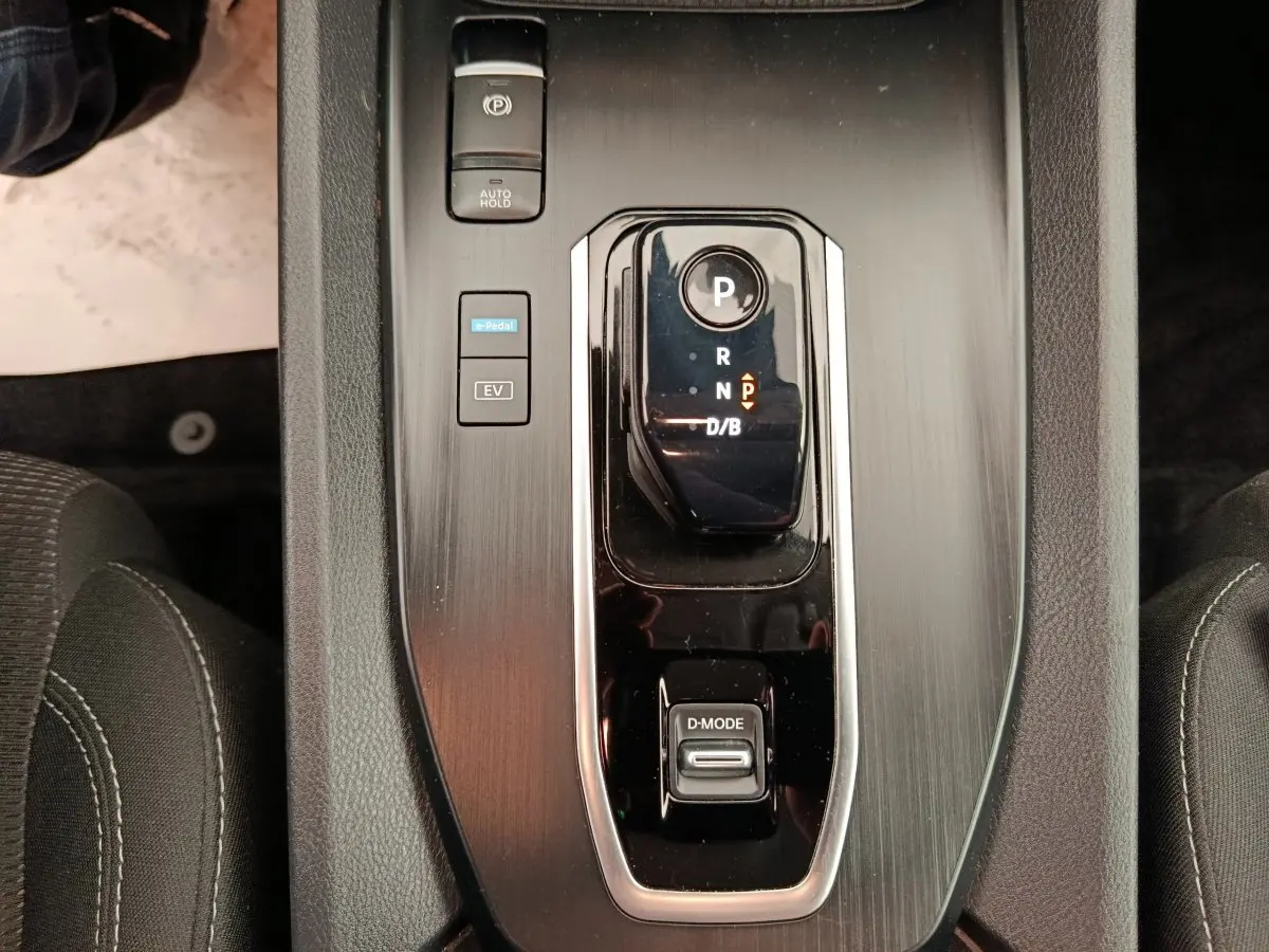 Vue rapprochée de la console centrale du Nissan Qashqai e-Power 2024, avec sélecteur de vitesse noir brillant et boutons de mode.