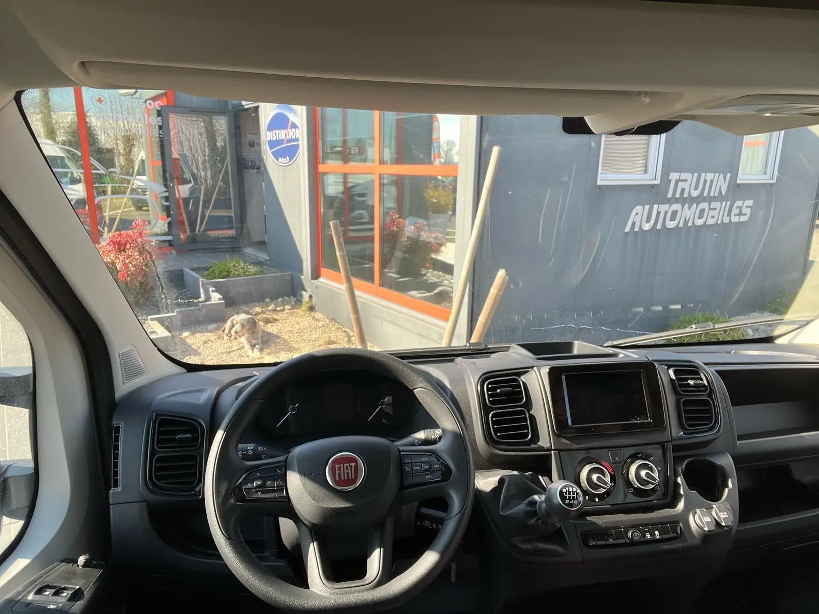 Vue intérieure du tableau de bord et volant noir du Fiat Ducato Fourgon 2023 avec boîte manuelle et écran central.