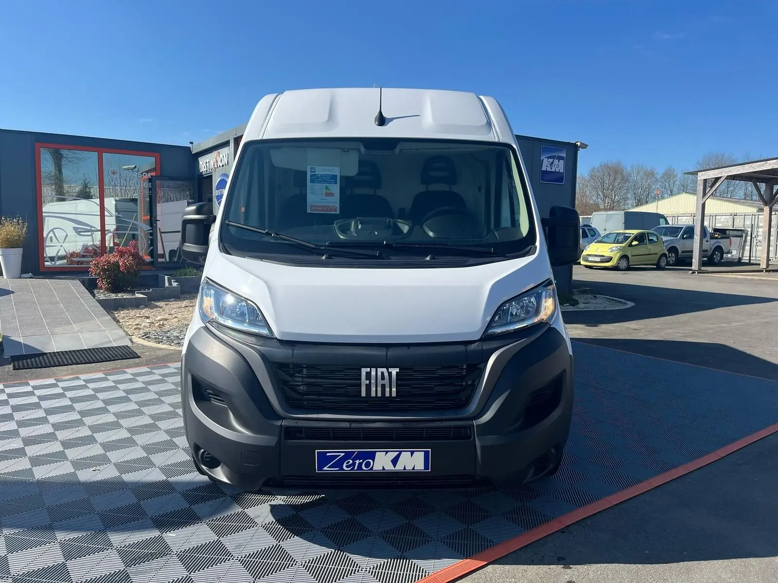 Vue frontale d'un FIAT Ducato Fourgon blanc 2023 avec calandre noire et logo FIAT bien visible.