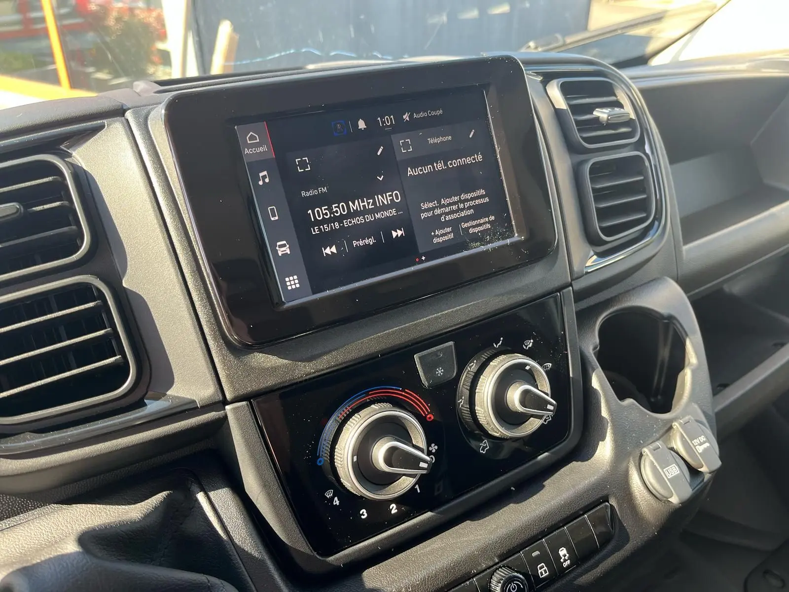 Vue rapprochée du tableau de bord du Fiat Ducato Fourgon 2023, montrant l'écran tactile et les commandes de climatisation.