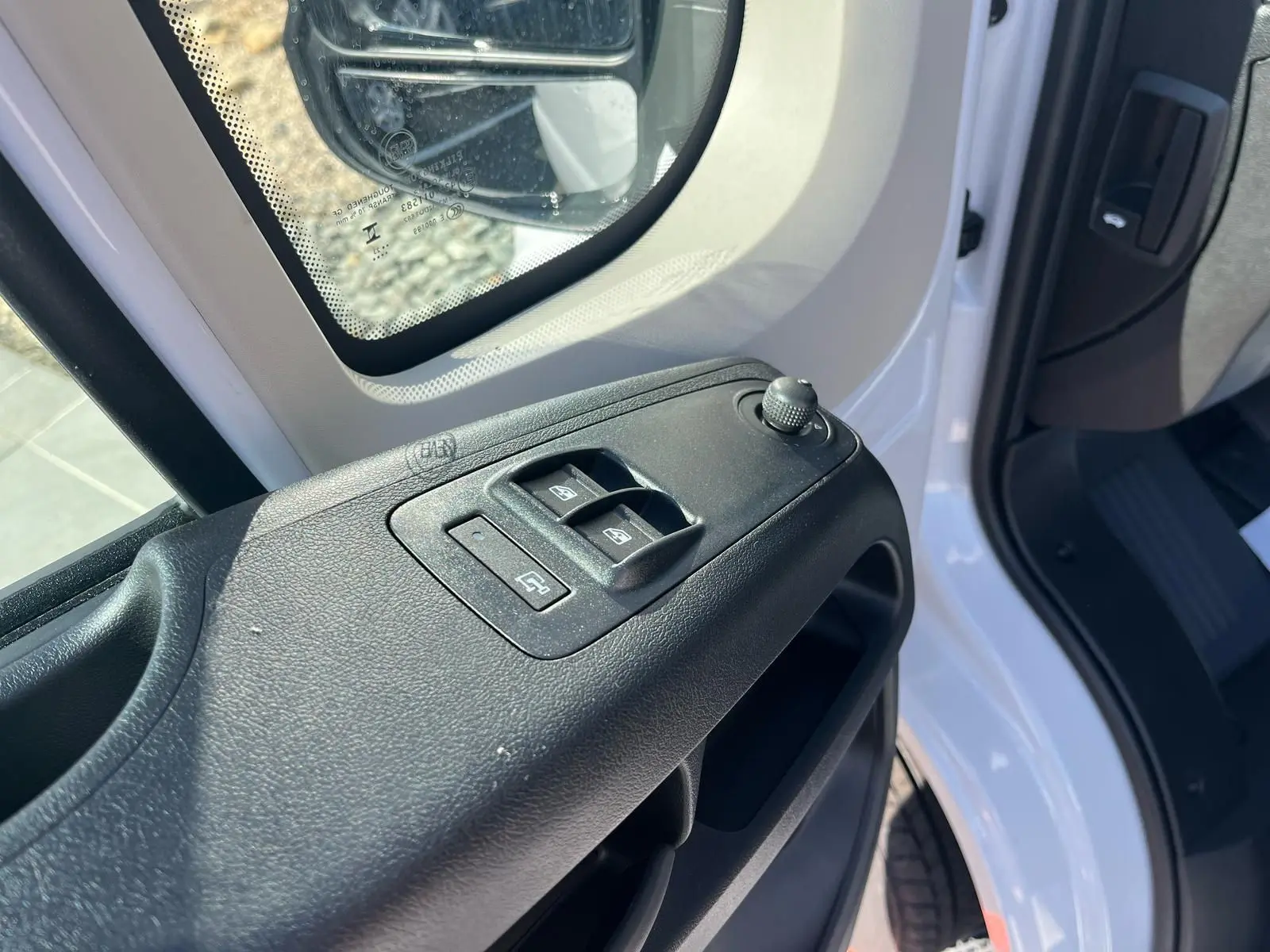 Détail des commandes des vitres sur la porte côté conducteur du FIAT Ducato Fourgon blanc 2023, vue rapprochée.