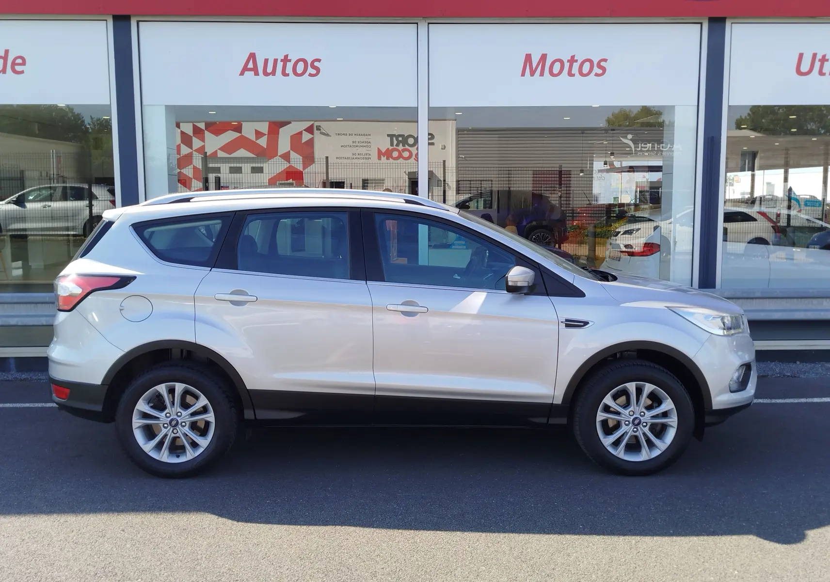 Vue latérale droite d'un Ford Kuga gris clair 2019, SUV compact avec jantes alliage et vitres teintées.