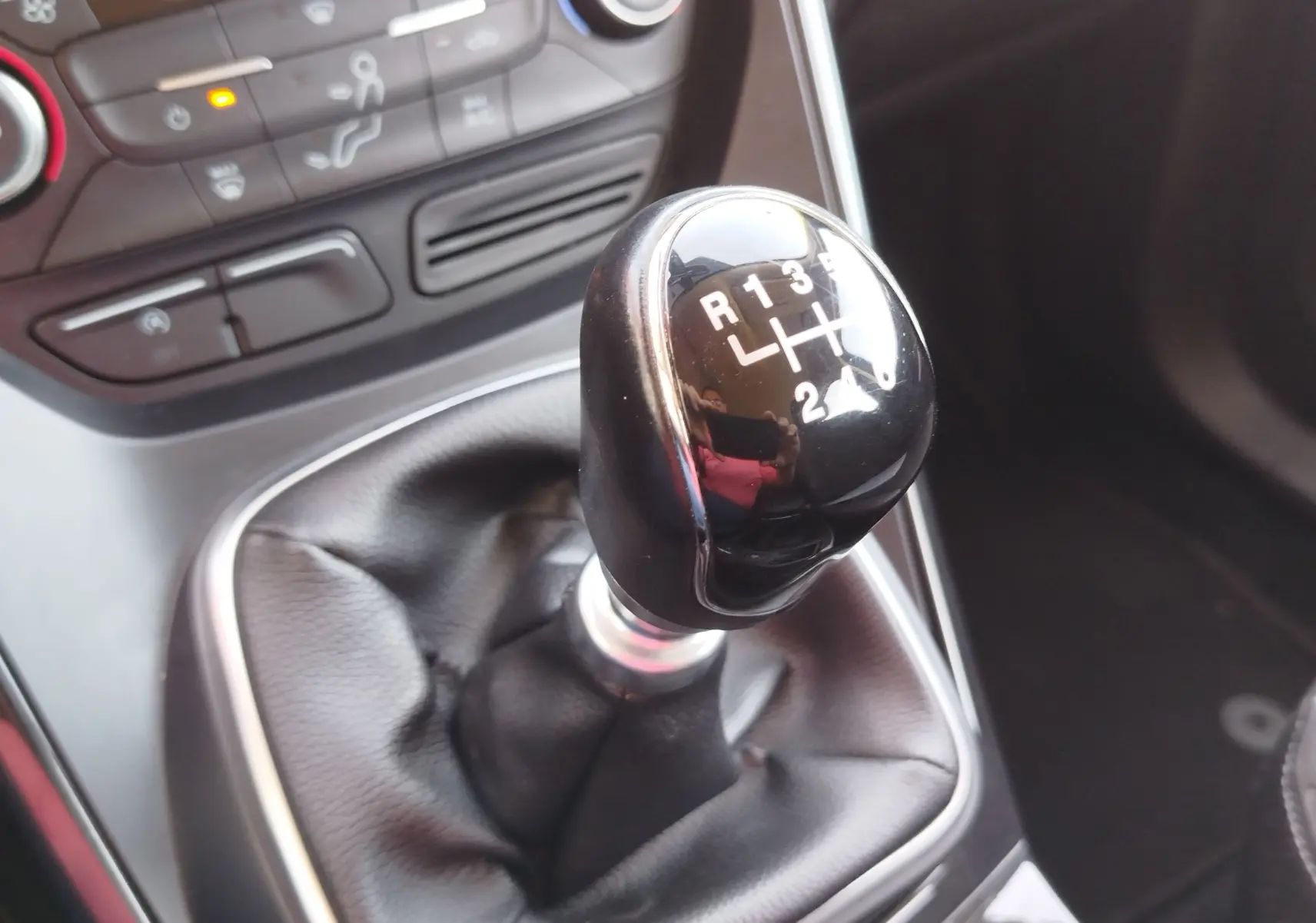 Le levier de vitesses manuel noir du Ford Kuga 2019, avec la console centrale et commandes de climatisation en arrière-plan.