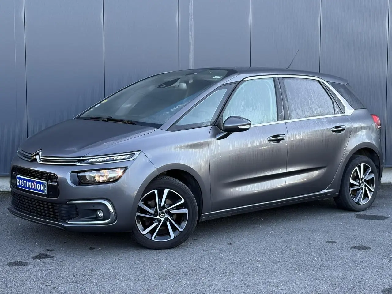 Citroën C4 Picasso gris Platinium vue 3/4 avant droit avec jantes alliage bi-ton et feux LED distinctifs.