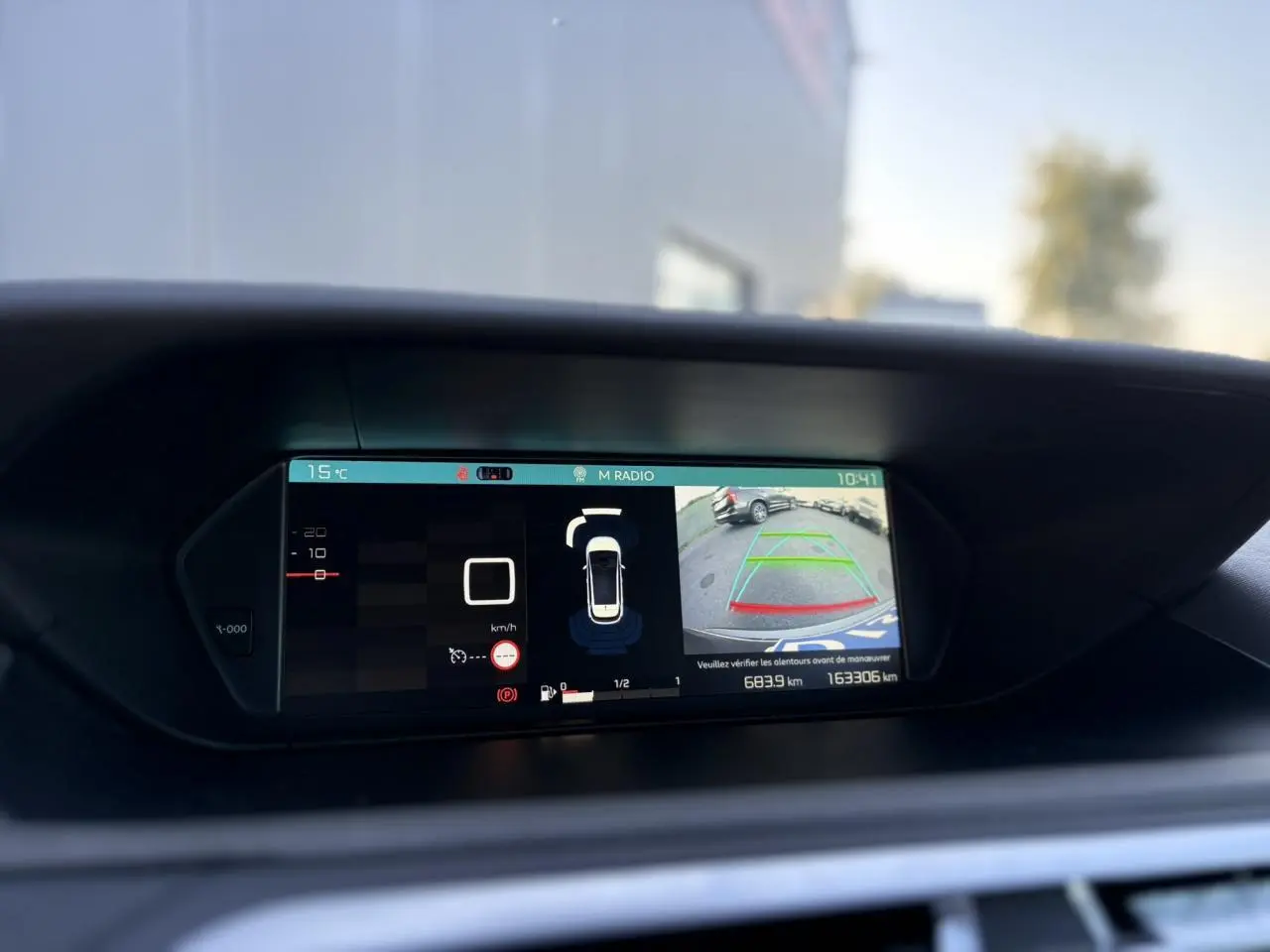 Écran de tableau de bord de Citroën C4 Picasso gris Platinium montrant la caméra de recul et les aides à la conduite.