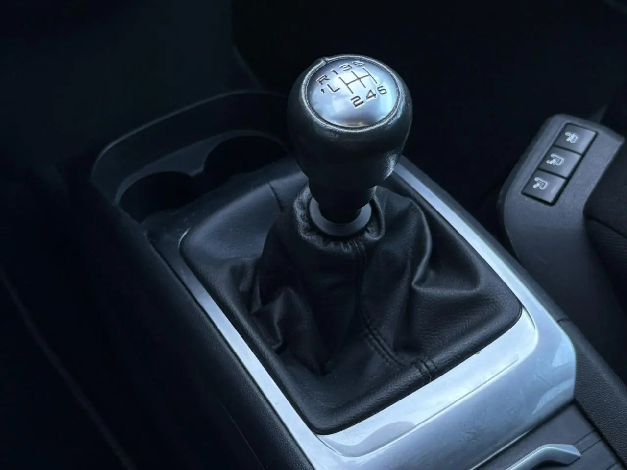 Le levier de vitesses manuel en cuir noir de la Citroën C4 Picasso 1.6 BlueHDI 120 vue en gros plan intérieur.