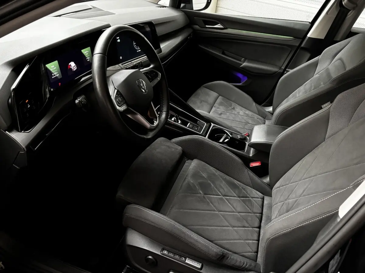 Intérieur gris foncé de la Volkswagen Golf 2024, vue côté conducteur, avec tableau de bord digital et volant cuir multifonctions.