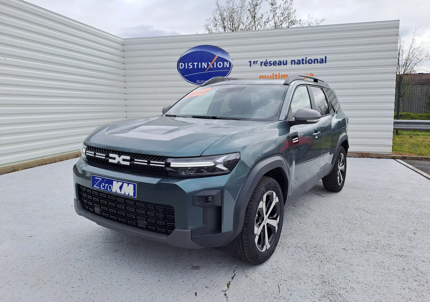 SUV Dacia Bigster vert cèdre en 3/4 avant droit, avec calandre noire distinctive et jantes bicolores.