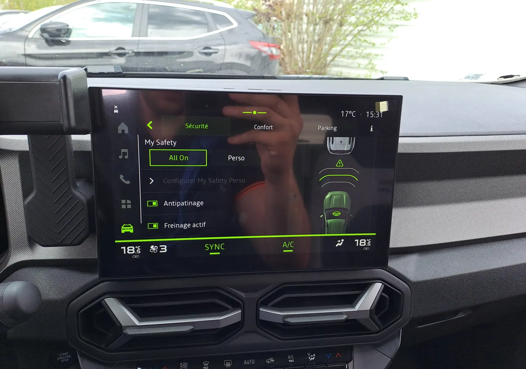 Vue intérieure centrée sur l'écran tactile du tableau de bord du Dacia Bigster Hybrid 155 en vert cèdre.