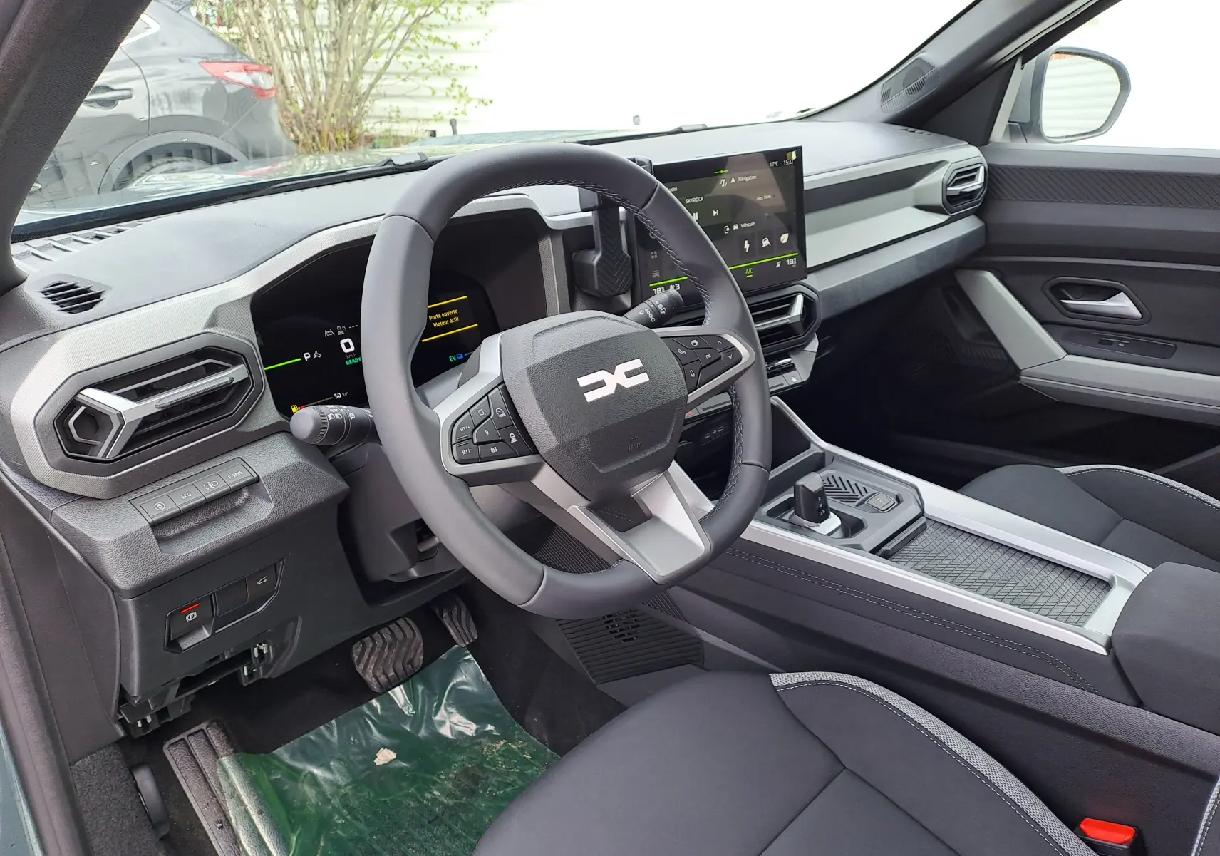 Vue intérieure côté conducteur du tableau de bord et volant du Dacia Bigster Hybrid 155, finition Journey, avec écran tactile central.