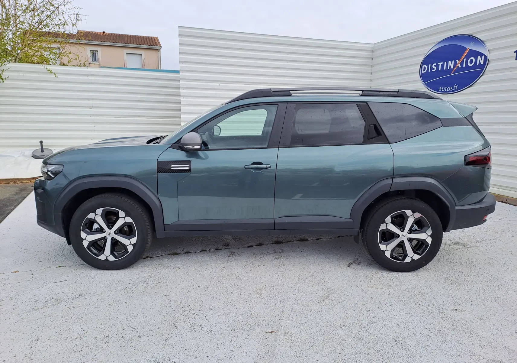 Vue de profil côté gauche du SUV Dacia Bigster vert cèdre 2026 avec jantes bi-ton et toit noir.