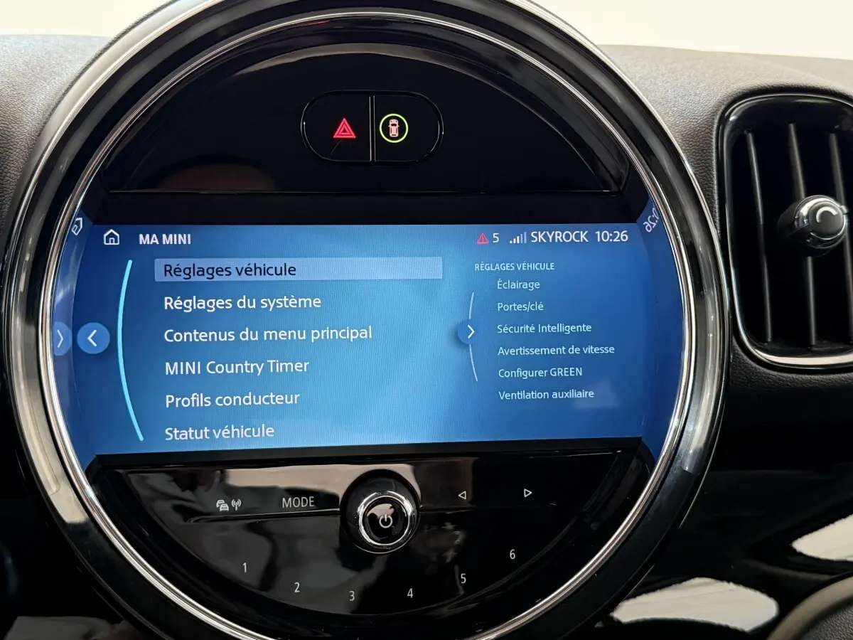 Écran tactile circulaire du système multimédia MINI Countryman 2023, affichant les réglages du véhicule.