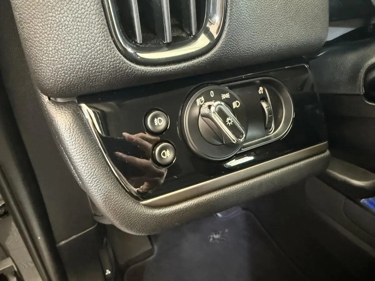 Gros plan sur le panneau de commande des phares et antibrouillards du tableau de bord noir du MINI Countryman gris clair.