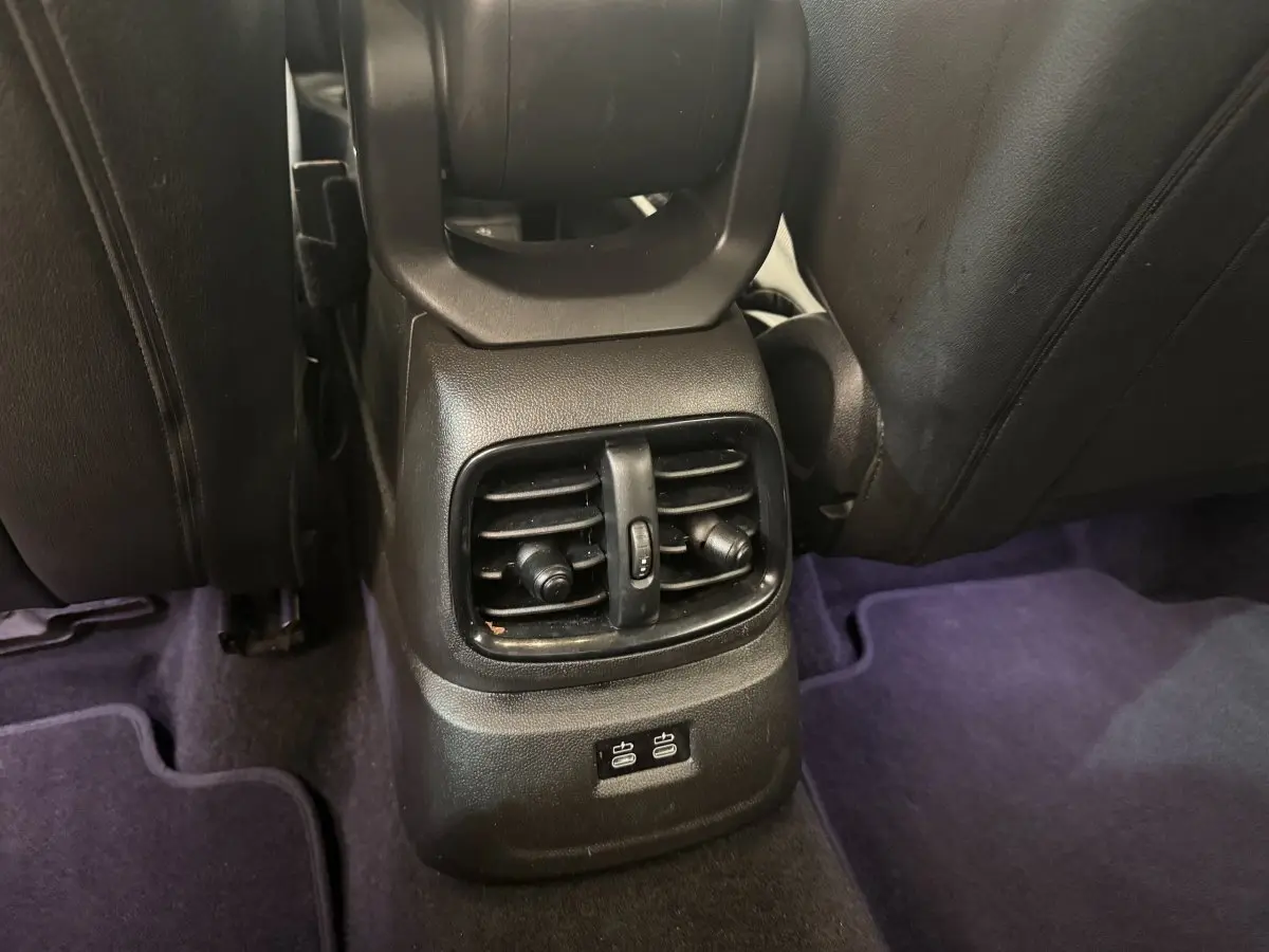 Vue rapprochée des aérateurs arrière et ports USB situés entre les sièges noirs d'un MINI Countryman gris clair.