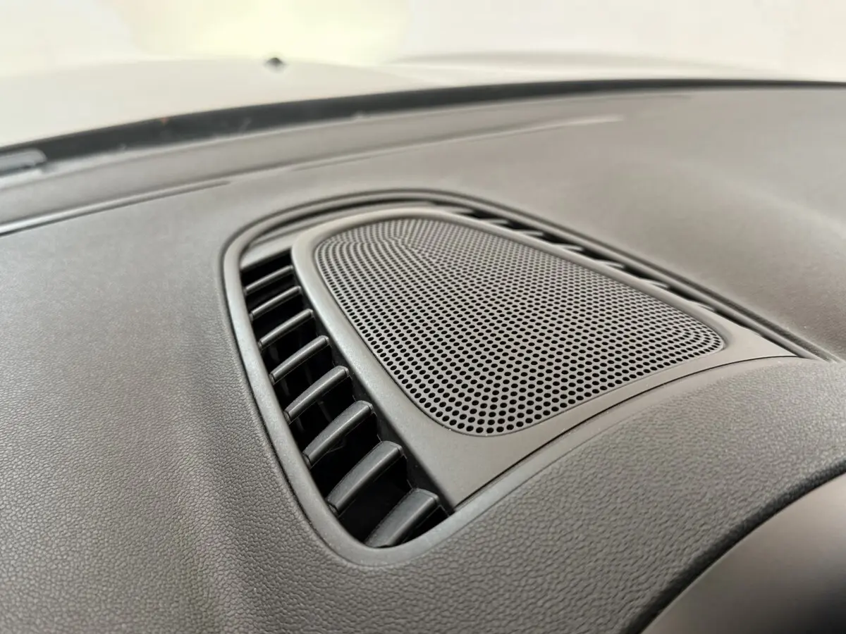 Gros plan sur la grille d’aération centrale noire du tableau de bord du MINI Countryman gris clair 2023.