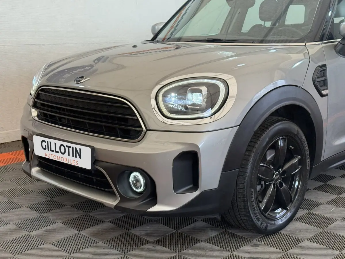 Vue 3/4 avant droit d'une MINI Countryman gris clair avec phares LED et jantes noires brillantes.